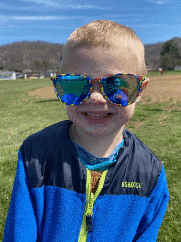 little boy in blue with puzzle piece sunglasses